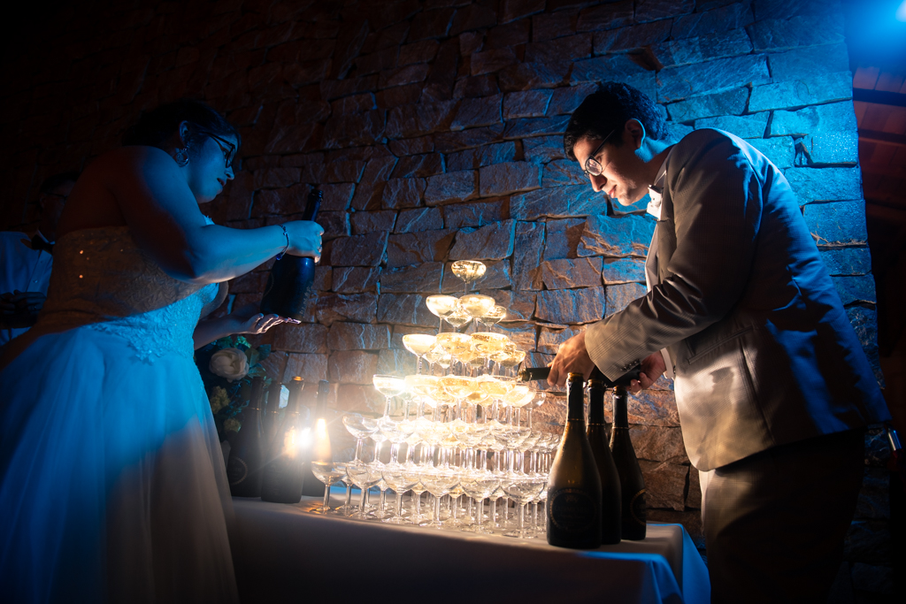 Couple de mariés versant le champagne sur une fontaine de champagne