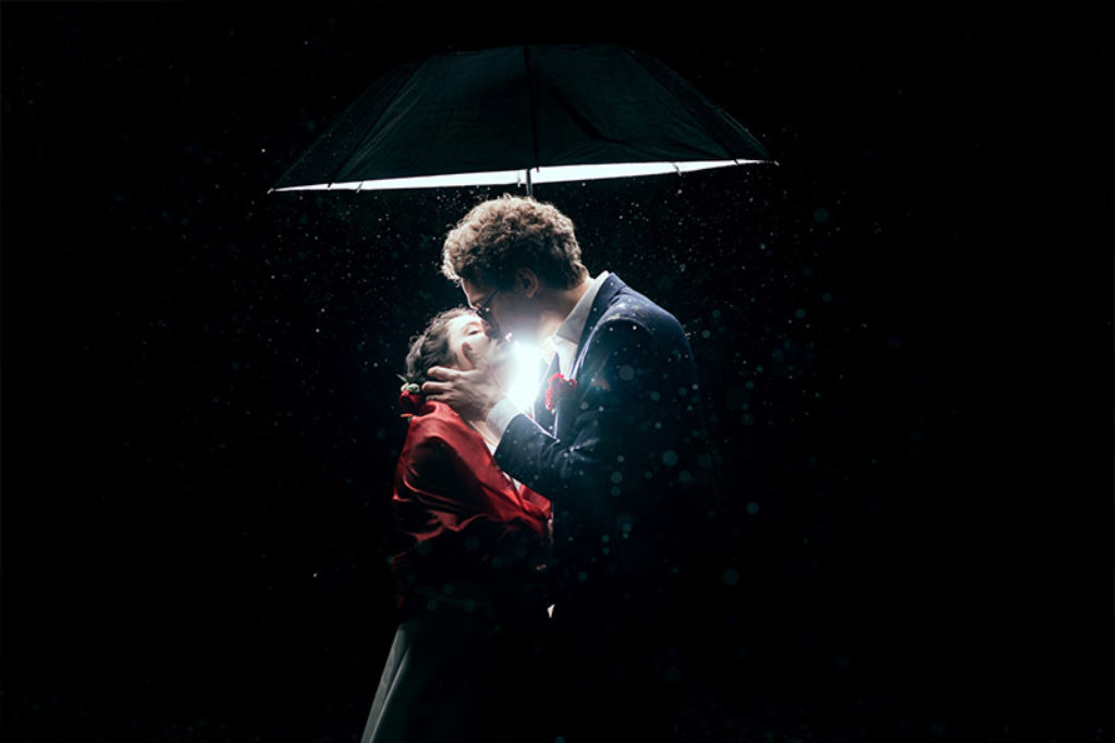 Wedding photo of a newly married couple under an umbrella