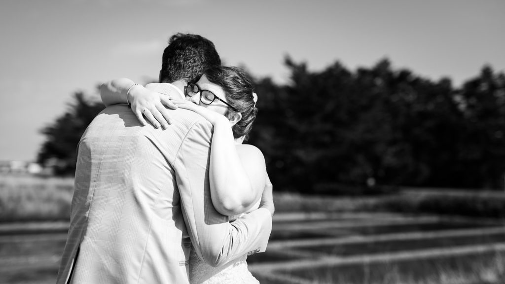 Couple de mariés s'enlassant au moment où ils se découvrent