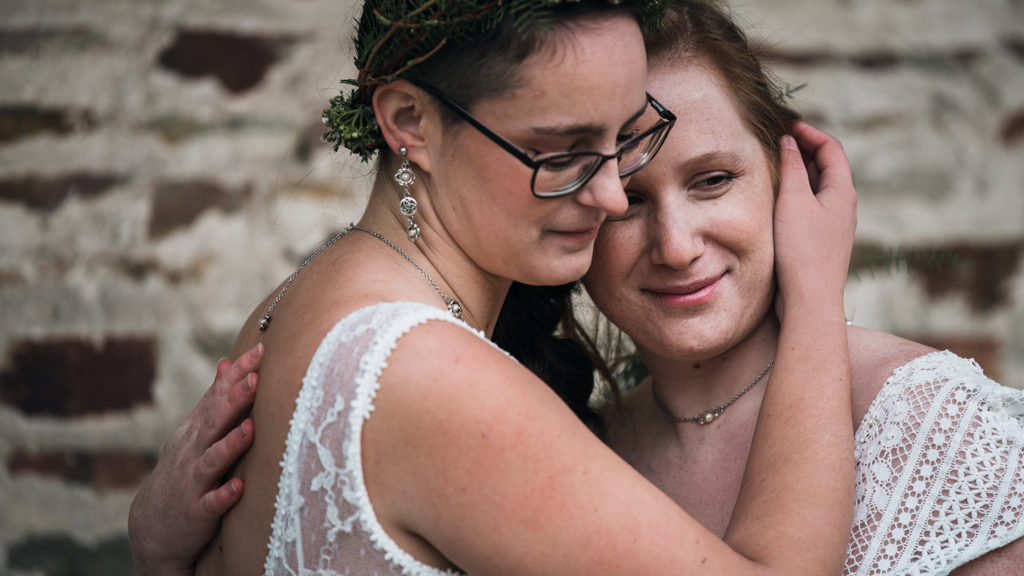 Couple de mariées dans les bras l'une de l'autre