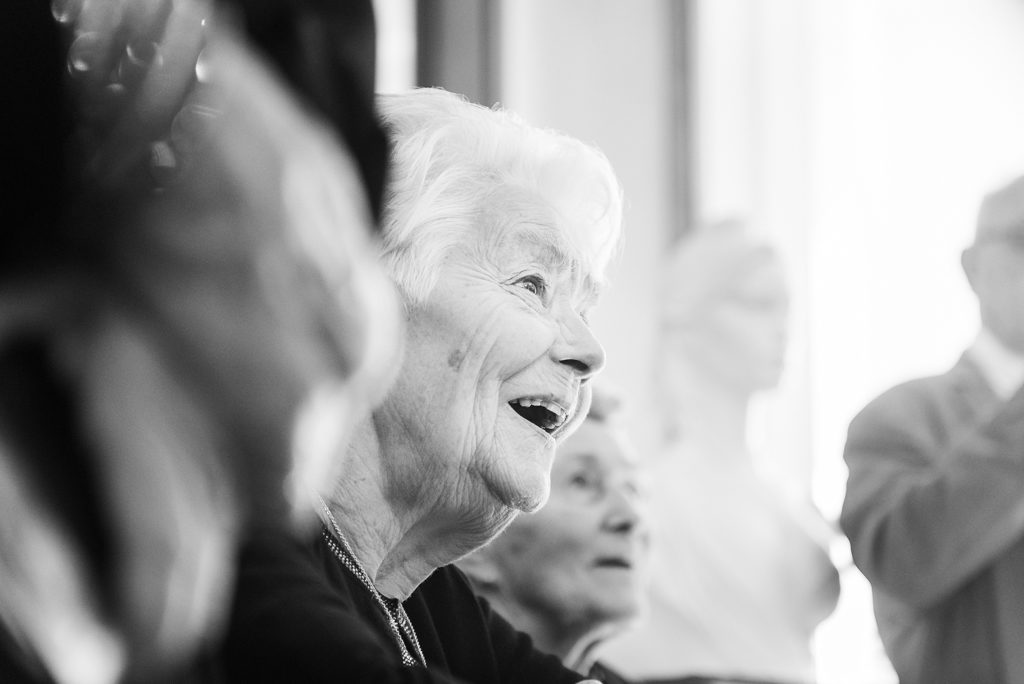 Grand-mère en train d'assister au mariage, le sourire jusqu'aux oreilles