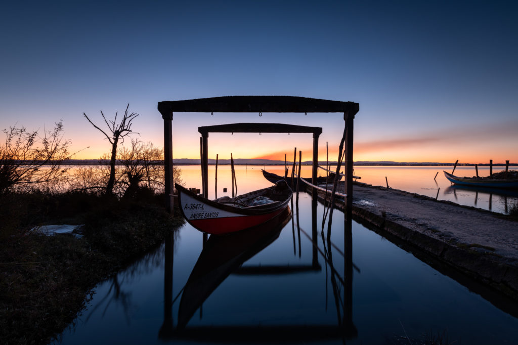 fishermen boats in Portugal at sunrise, under wooden doors.