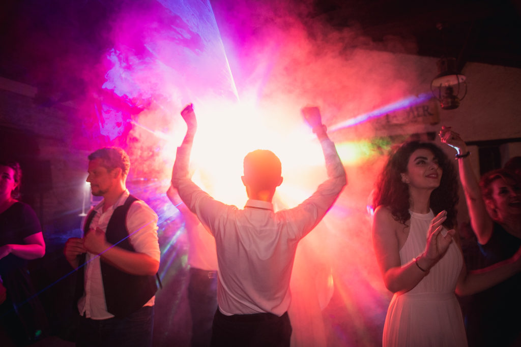 Personne de dos, dansant les bras levé, avec des lumières formant un halo autour de lui