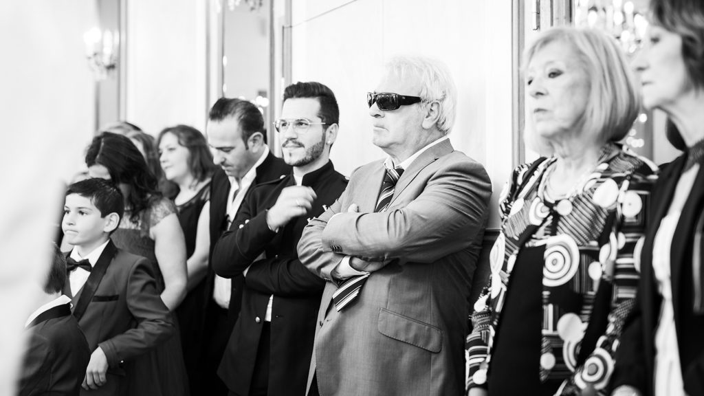 invités à un mariage lors de la cérémonie civile. L'un d'eux porte des lunettes de soleil