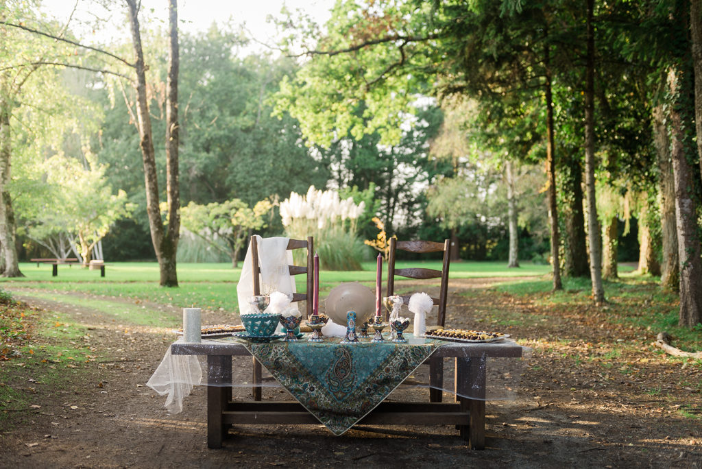 table de cérémonie iranienne, ornée d'un beau tissu brodé et garnie de douceurs. Deux chaises sont préparées pour le couple