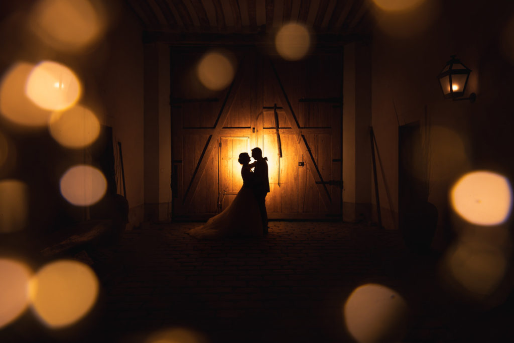 Shadow of a couple in front of a wooden door, play on lights and colours.