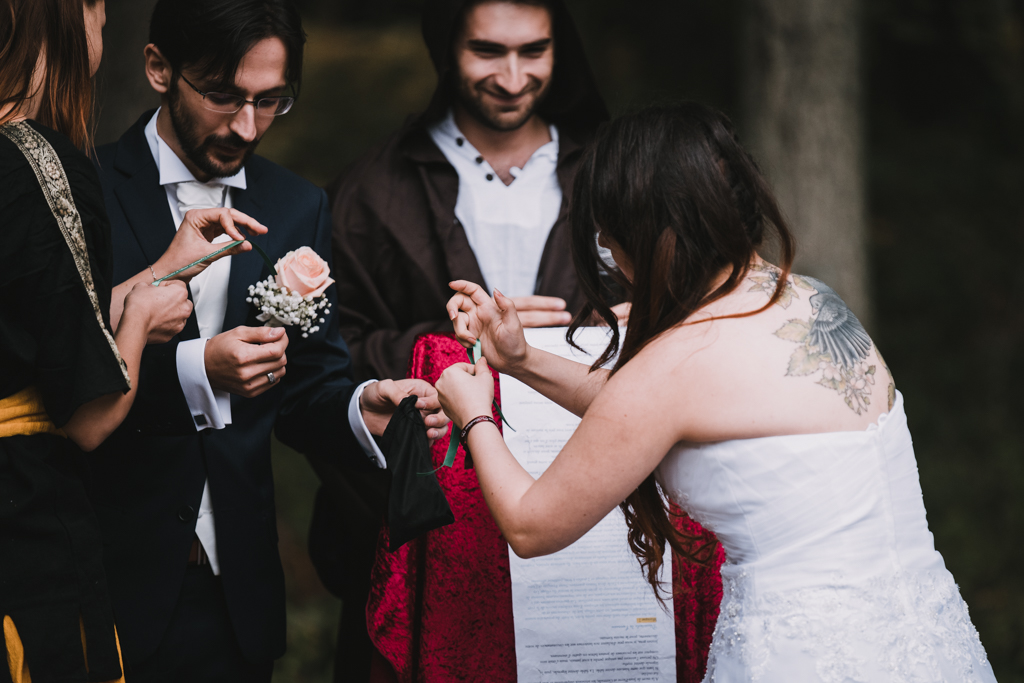 Mariée nouant un ruban autour du poignet de son mari pendant la cérémonie laïque
