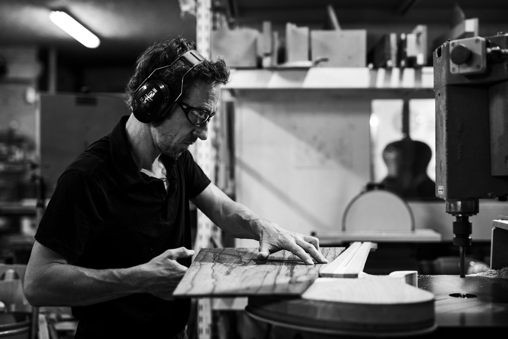 luthier en train de vérifier l'ajustement entre la table et le manche