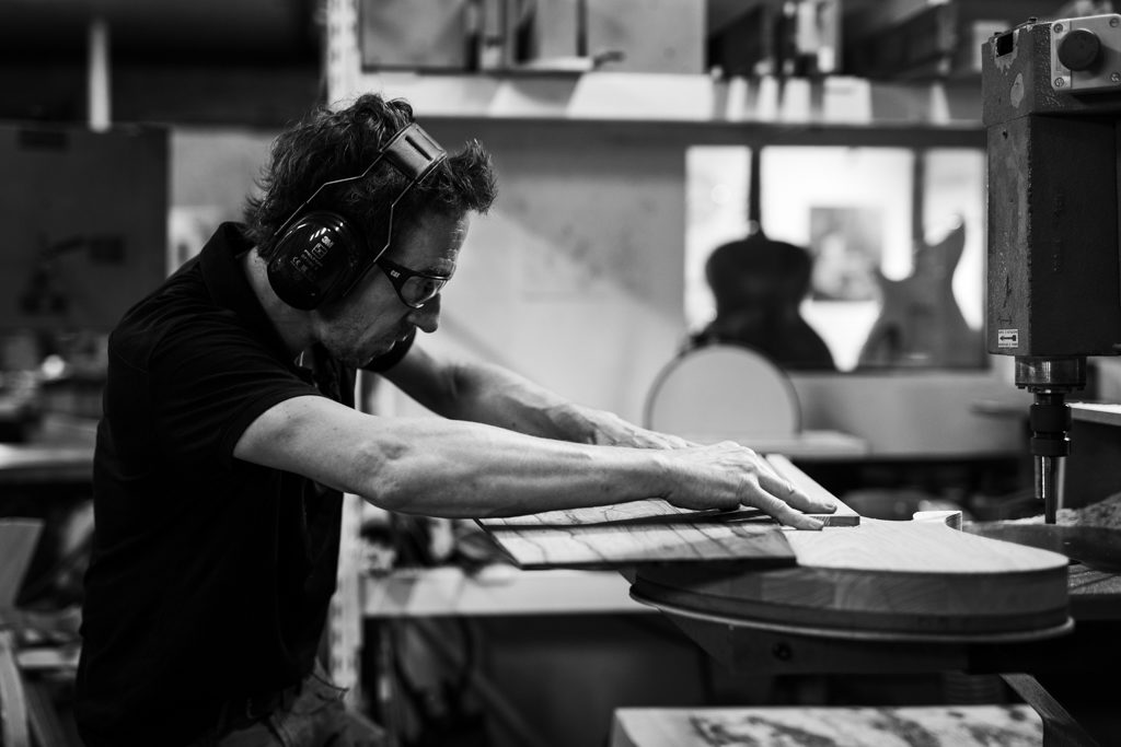 luthier en train de vérifier l'ajustement entre la table et le manche
