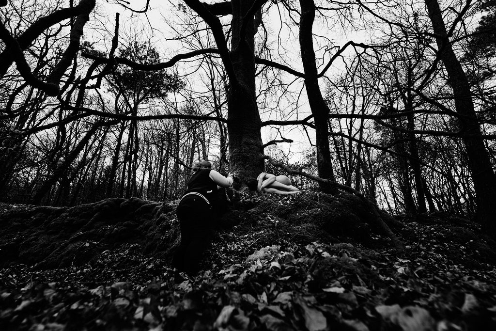 Photographe prenant en photo une femme nue dans la forêt