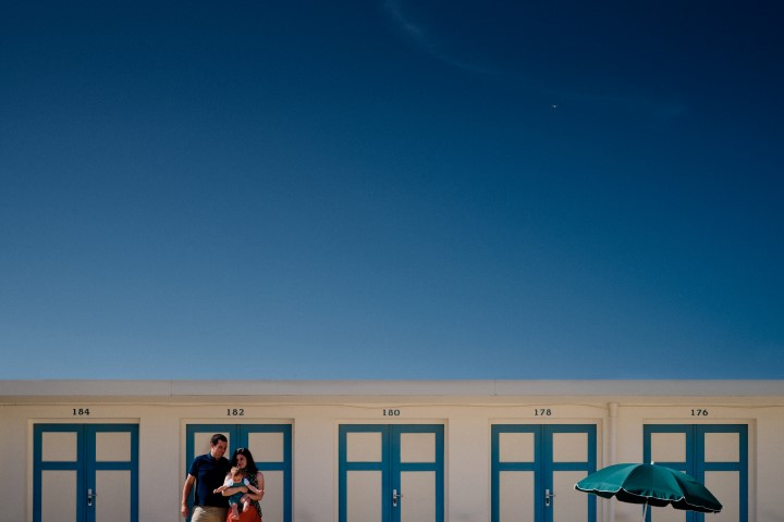 famille devant des cabines de plage sous un grand ciel bleu pendant une seance photo lifestyle