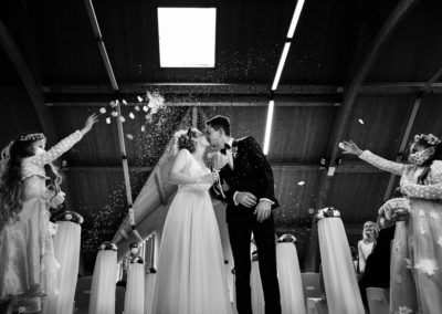 Couple de mariés s'embrassant sous les confettis lors de leur mariage en Alsace à la mairie