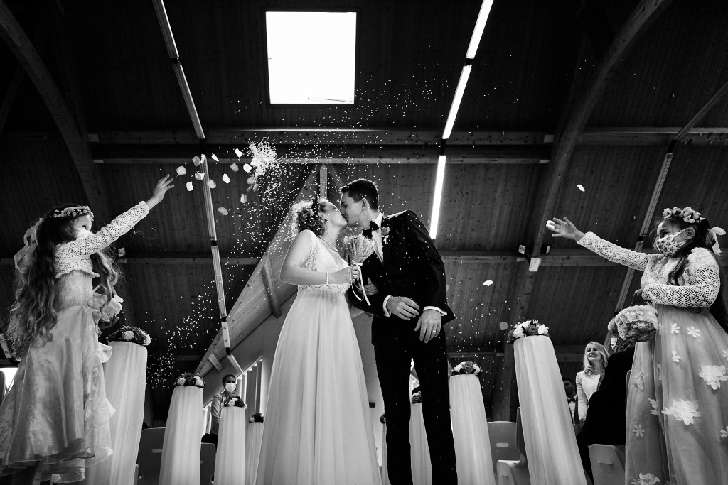 Couple de mariés s'embrassant sous les confettis lors de leur mariage en Alsace à la mairie