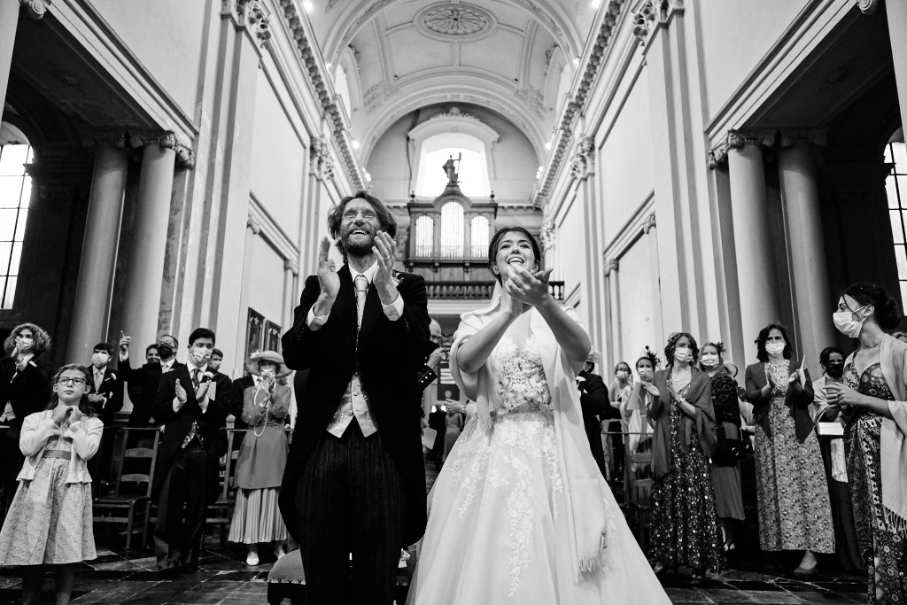 Couple de mariés applaudissant lors de leur mariage à l'Eglise de Gembloux