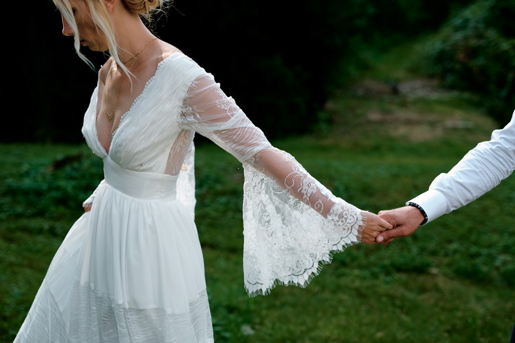 Photo prise par un photographe de mariage à Druillat, la mariée entraîne le marié par la main derrière elle