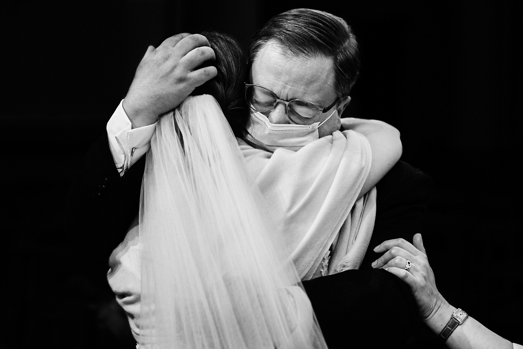 photo de photographe de mariage, un père prend la mariée dans ses bras, submergé par l'émotion