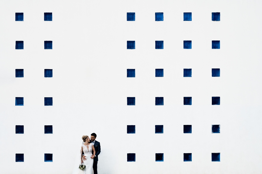 seance-photo-graphique Couple posant devant un bâtiment de gymnase. Des carrés forment un rendu très géométrique
