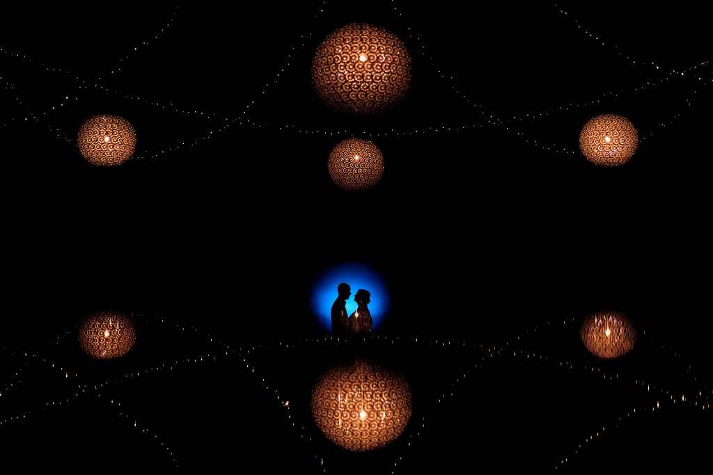 Couple de mariés en ombre chinoise sur un cercle bleu avec des lustres ronds jaunes autour d'eux