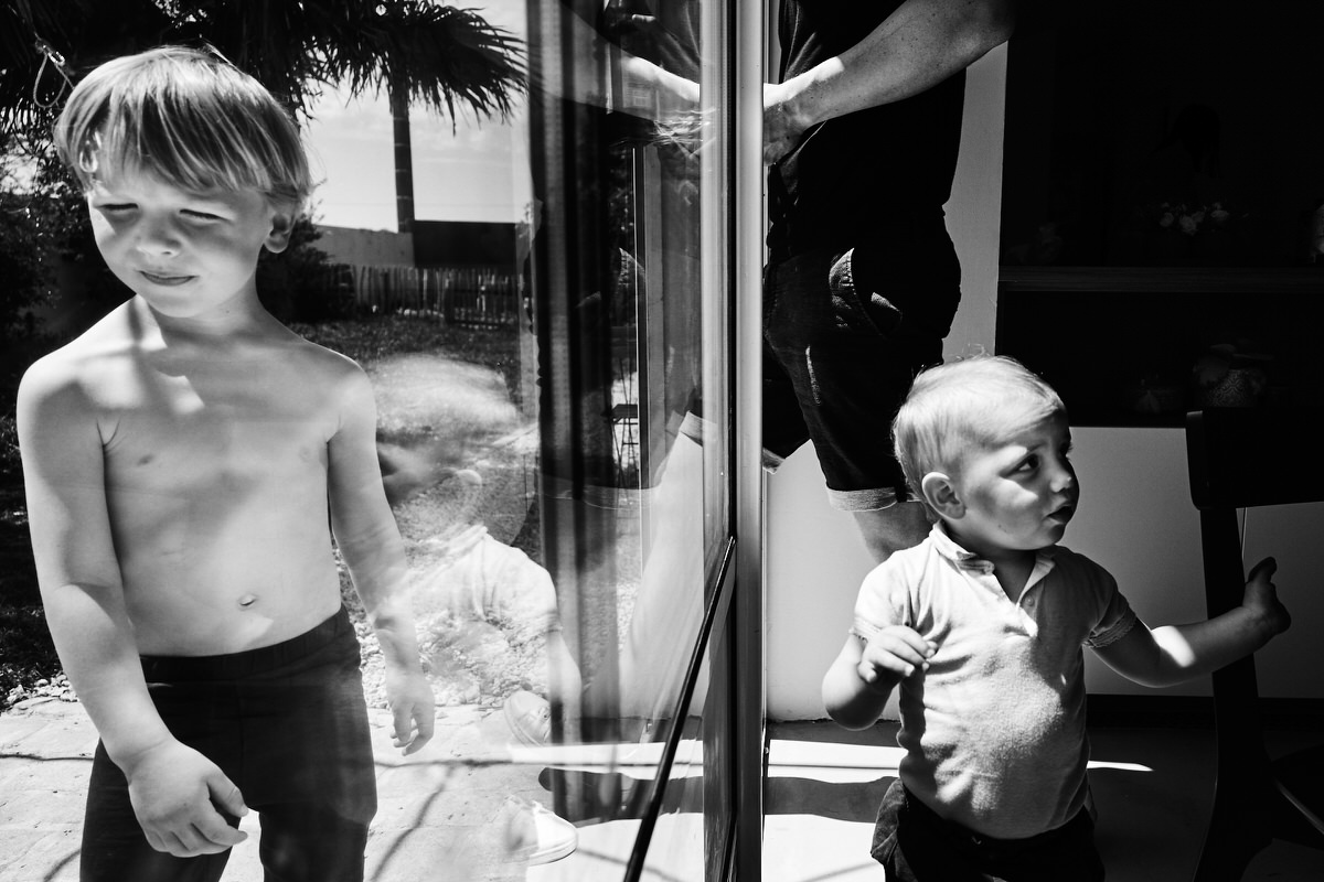 Photo de deux enfants chacun d'un côté d'une vitre