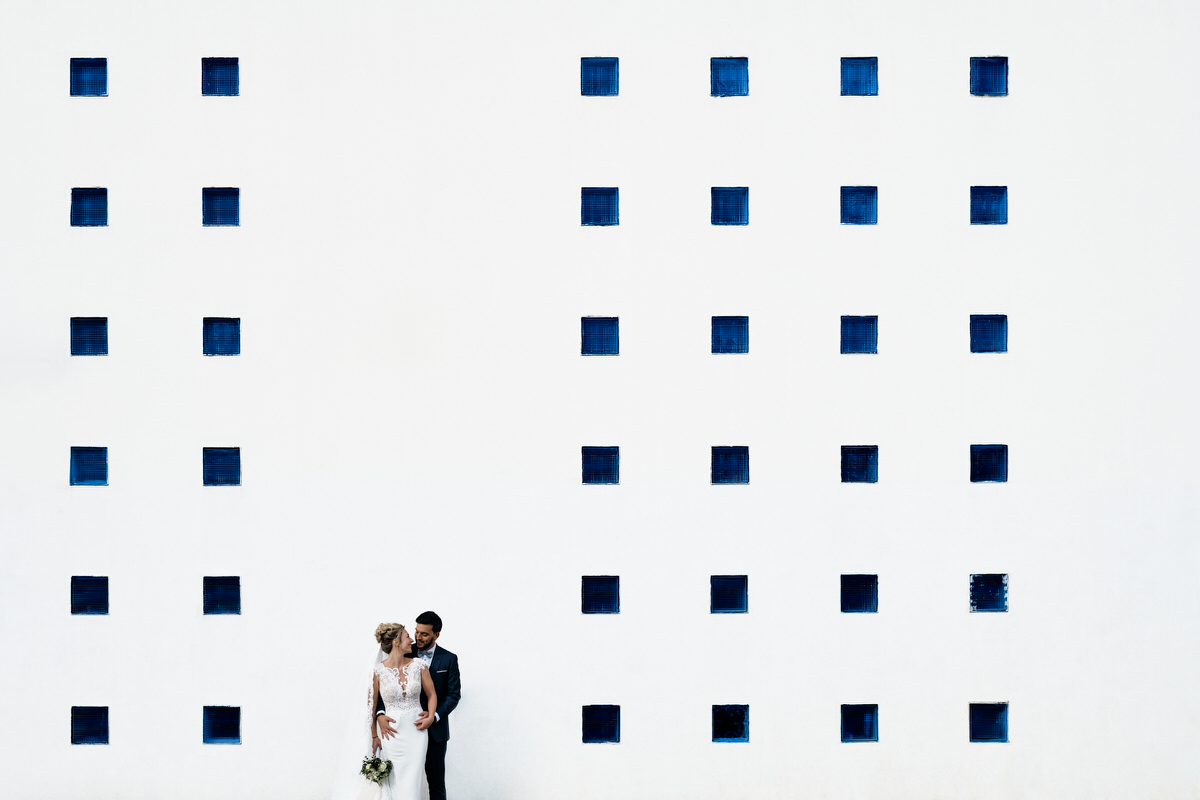 Photo d'un couple devant un mur de carreaux bleus