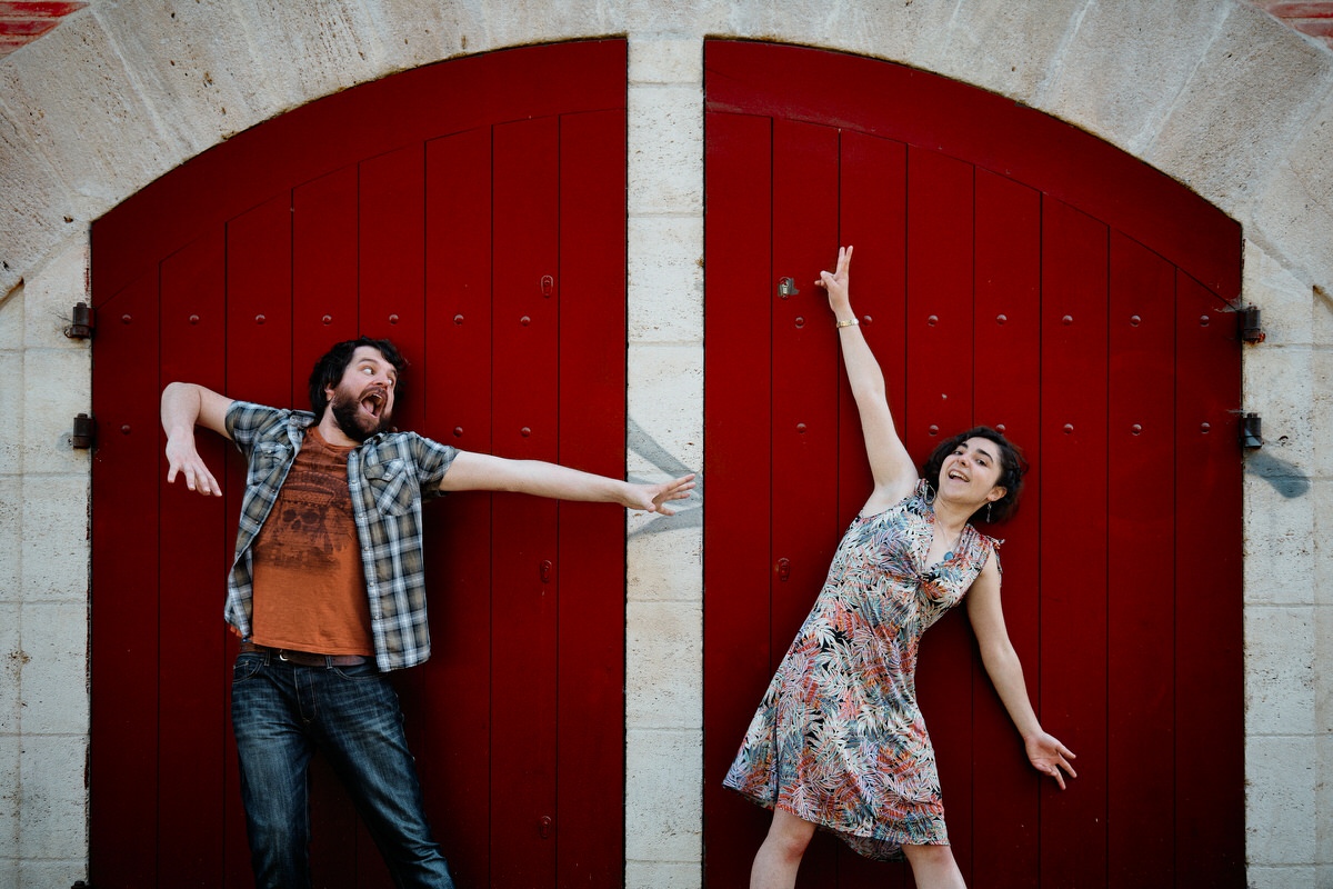 Couple devant une porte rouge pendant une séance photo lifestyle