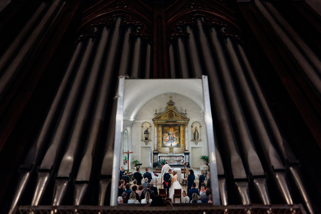 Bisou des mariés pris depuis le miroir de l'orgue de l'église